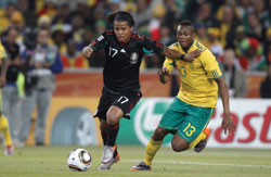 Giovani Dos Santos of Mexico (left) and Kagisho Dikgacoi of South Africa (right) in action during a World Cup match June 11, 2010 in Johannesburg, South Africa. &copy; Diademimages - Dreamstime.com
