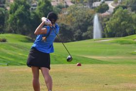 Female golf professional on course in competition